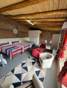 a room with two beds and a couch and chairs at Cabaña San Antonio2 in Tinogasta