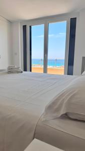 a bedroom with a bed with a view of the beach at Glory Guest House Sea View in Mandaradoni +28 photos