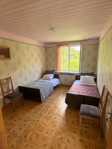 two beds in a room with a window and two chairs at Гостевой Дом на природе in Vanadzor +17 photos