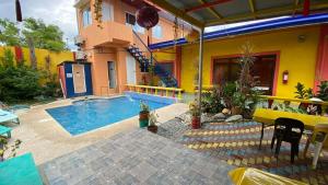 a house with a swimming pool next to a building at Buku Island House in san juan la union