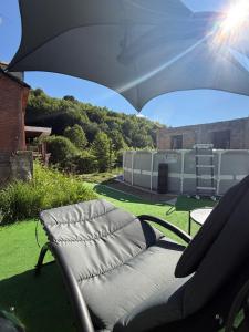 a chair sitting under an umbrella on a lawn at Гостевой Дом на природе in Vanadzor