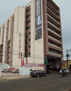 um carro está estacionado em frente a um edifício em Center Patos Hotel em Patos de Minas