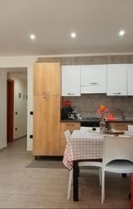 a kitchen with white cabinets and a table with chairs at B&B ombra dei pini in San Leucio del Sannio +16 photos