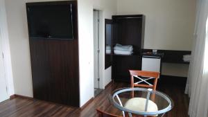 a room with a table and a television in a room at Center Patos Hotel in Patos de Minas +19 photos