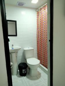 a bathroom with a toilet and a sink at Casa hotel Comunicar Nini in Bogotá