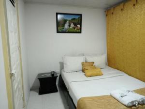 a white room with a bed with two pillows on it at Casa hotel Comunicar Nini in Bogotá +43 photos