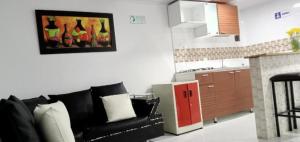 a living room with a couch and a painting of wine bottles at Casa hotel Comunicar Nini in Bogotá