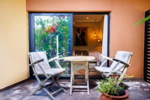 a patio with three chairs and a table and a window at Bakadaji Hotel in Serekunda +1 photo