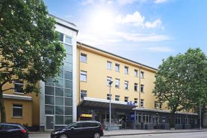 a yellow building with cars parked in front of it at a&o Stuttgart City in Stuttgart