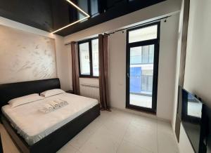 a small bedroom with a bed and a window at Apartament Poseidon in Mamaia Sat/Năvodari