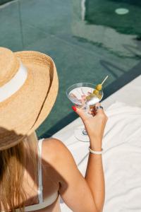 a woman wearing a straw hat holding a drink at Oporto Fly Hotel in Maia