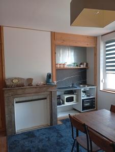 a living room with a table and a kitchen at L'immeuble de Didier et Fabien in Guînes