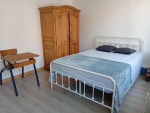a bedroom with a bed and a table and a chair at L'immeuble de Didier et Fabien in Guînes