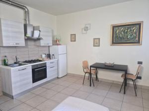 eine Küche mit Herd und einem Tisch mit Stühlen in der Unterkunft Il Giarolo in Cameriano