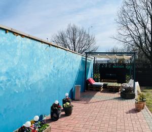 a patio with a blue wall and some potted plants at Pokoje Gościnne u Kovi in Legnica