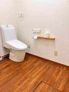 a bathroom with a toilet and a wooden floor at 古民家一棟貸切 民宿 潤 松山市駅徒歩5分 銀天街徒歩2分 無料駐車場1台付き in Matsuyama +16 photos