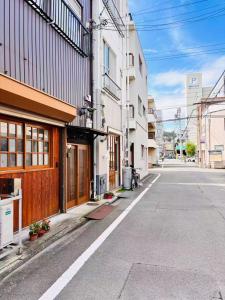 an empty street in a city with buildings at 古民家一棟貸切 民宿 潤 松山市駅徒歩5分 銀天街徒歩2分 無料駐車場1台付き in Matsuyama