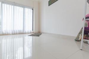 a white room with a window and a rug on the floor at Urbanview Hotel Tridaya Cisarua Puncak in Kopo 2