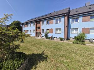 an apartment building with a lawn in front of it at Haus Marinus in Puttgarden