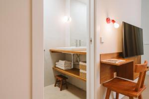 a bathroom with a sink and a desk with a tv at Apartamentos Turísticos - ELBUZONROJO in Burgos