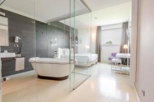 a bathroom with a bath tub and a sink at Hotel For You in Cernusco sul Naviglio +44 photos