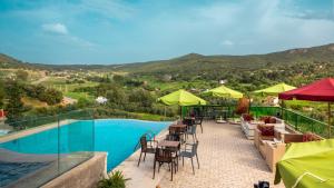 a patio with tables and chairs and a swimming pool at Dar Zayane in Khenifra