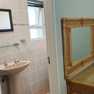 a bathroom with a sink and a mirror at Praia Longa 4 in Rand Rifles
