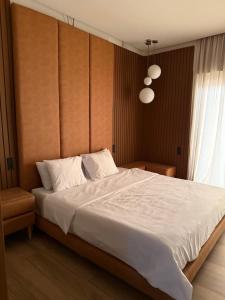 a bedroom with a large white bed and a window at Penthouse Meknes in Meknès