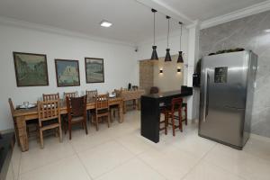 a kitchen and dining room with a stainless steel refrigerator at Pousada House Garden in Goiânia