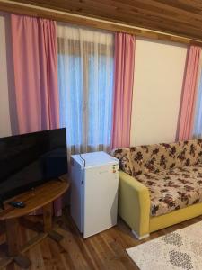 a living room with a couch and a flat screen tv at Sedir Palas in Cıralı