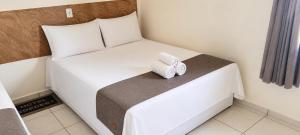 a bedroom with a bed with two towels on it at Hotel Goedert in Major Vieira
