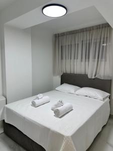 a bedroom with a bed with towels on it at Nōema Residences II in Nafpaktos