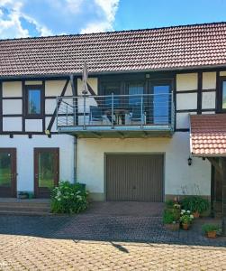 a house with a balcony and a patio at Hainich-Ferienwohnung in Hörselberg-Hainich