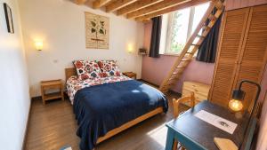 a small bedroom with a bed and a ladder at L'école buissonnière chambres et table d'hôtes in La Celle-Dunoise