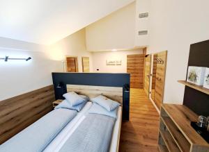 a bedroom with two beds with blue pillows at Da`Sporrer Hotel & Wirtshaus in Neunburg vorm Wald