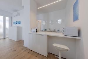 a white kitchen with a counter and a sink at HOMESTWENTY3 - Home seven - Renovated in 2026 in Caorle