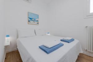 a white bed with two towels on top of it at HOMESTWENTY3 - Home seven - Renovated in 2026 in Caorle