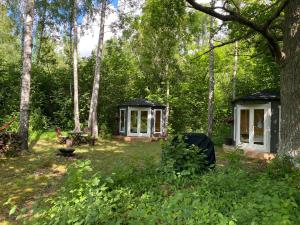 a gazebo and a picnic table in a forest at Pendu talu kämping in Orissaare