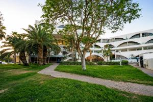 a building with palm trees in front of it at Milano Suite in Lev Eilat in Eilat