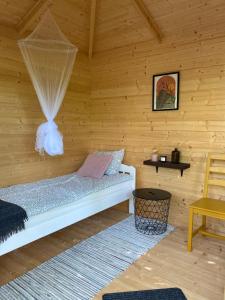 a bedroom with a bed in a wooden room at Pendu talu kämping in Orissaare