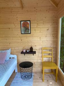 a room with a wooden wall with a bench and a chair at Pendu talu kämping in Orissaare