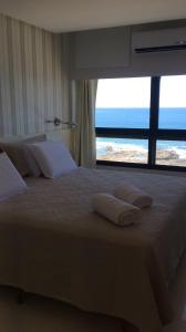 um quarto com uma cama grande e vista para o oceano em Lindo Apto em Ondina com Vista em Salvador