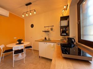 a kitchen with a small table and a kitchen with yellow walls at Cozy House in Corte in Vimodrone