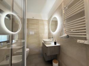 a bathroom with a sink and a toilet and mirrors at Cozy House in Corte in Vimodrone