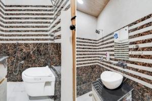 a bathroom with a toilet and a sink at Hotel Aarambh By Ramayana Grand-Near Ram Mandir Ayodhya in Ayodhya