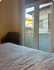 a bedroom with a bed and a window and a chair at Jasmine Studio 3 Pigadia Siatista in Siátista