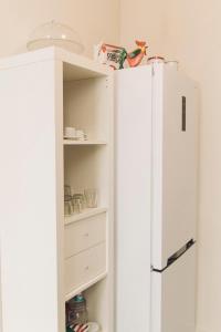 a white refrigerator in a kitchen next to a shelf at Casa Kilig 40 in Santa Cruz de Tenerife
