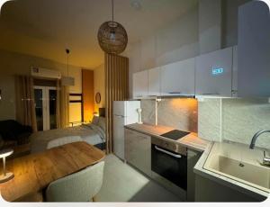 a kitchen with white cabinets and a table and a dining room at Jasmine Studio 3 Pigadia Siatista in Siátista