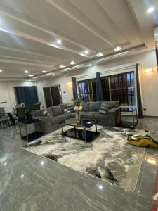 a living room with couches and a table on a marble floor at AMINA luxury SUITE in Lomé