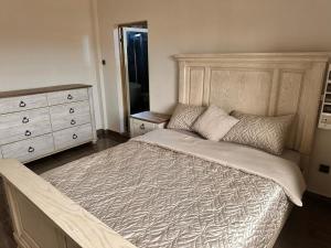 a bedroom with a large bed and a dresser at AMINA luxury SUITE in Lomé